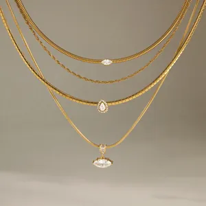 Close-up of layered gold titanium steel necklaces featuring elegant crystal pendants