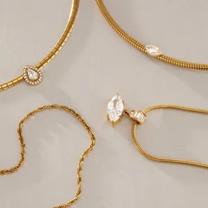 Detail view of gold-finished titanium steel necklaces with sparkling zircon pendants