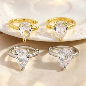 Detailed view of pear-shaped cubic zirconia ear cuffs in gold and silver plating.