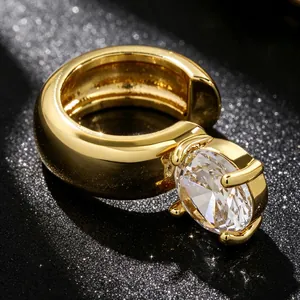 Macro detail of a high-end gold ear cuff set with a large sparkling round zircon.