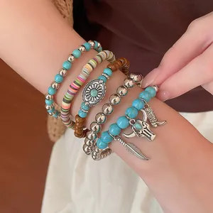 Detail van boheemse armbandenset met turquoise kralen en een stierenschedel-hanger.