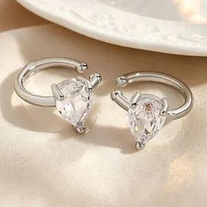 Close-up of elegant silver ear cuffs featuring sparkling pear-cut cubic zirconia stones