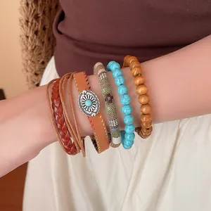 Detailweergave van gestapelde armbanden in boho-stijl met houten en turkooizen kralen