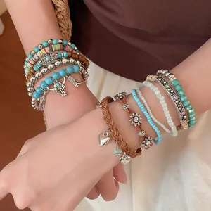 Close-up van Boheemse etnische kralenarmbandenset met hart- en zonhangers om de pols