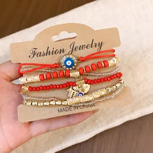 Bohemian style multi-layer red bead bracelet set featuring evil eye and hamsa hand charms