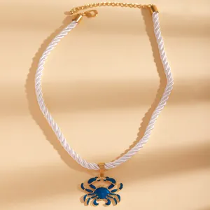 Detailed view of a nautical white twisted rope necklace featuring a blue enamel crab pendant