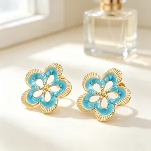 Primer plano detallado de pendientes de botón vintage con flores huecas y esmalte azul