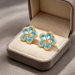 Detalle de los pendientes de botón vintage con flores de esmalte azul en caja de terciopelo