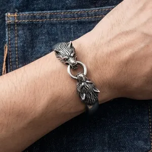 Detailed close-up showing the intricate texture of the vintage double wolf head steel bangle.