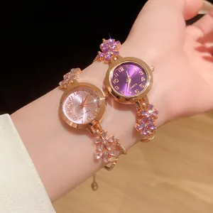 Gros plan sur deux montres-bracelets en or rose ornées de cristaux de fleurs roses