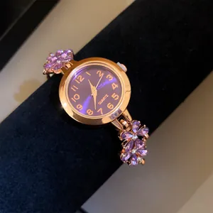 Vue détaillée d'une montre à quartz en or rose avec d'élégantes fleurs violettes.
