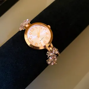 Vue détaillée de l'élégante montre ronde en or rose avec détail de bracelet floral rose