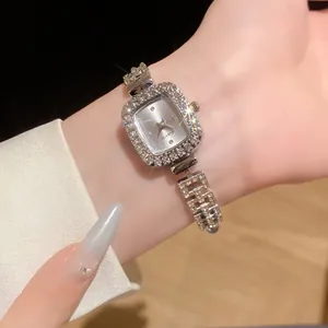 Gros plan d'une montre bracelet argentée avec des strass étincelants au poignet