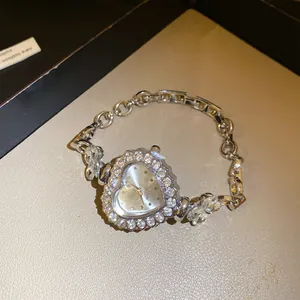 Gros plan d'une élégante montre strass en forme de cœur avec bracelet chaîne argent ajustable