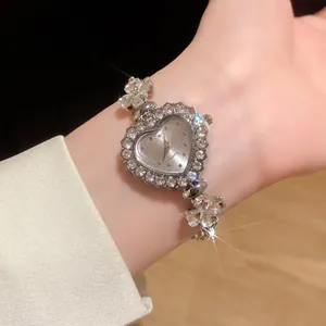 Vue détaillée de près d'une montre argentée en forme de cœur avec bracelet en strass
