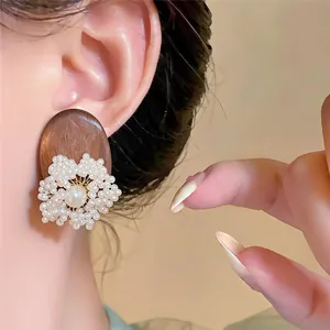 Detailed view of ethnic style wood stud earring featuring an elegant pearl flower design