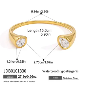 Detail view of a stainless steel C-shaped open bangle with two pear-shaped zirconia stones.