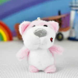 Close-up view of a cute pink and white plush dog keychain with embroidered heart detail.