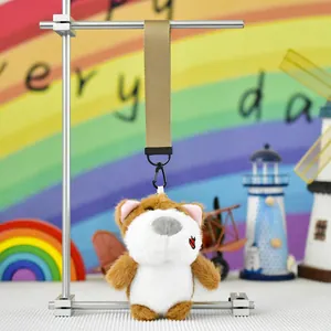 Detailed view of cute plush dog keychain with khaki lanyard hanging on display stand