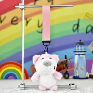 Detailed view of a cute pink and white plush dog pendant with a sturdy pink fabric strap