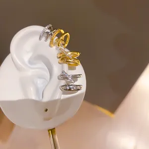 Detalle de primer plano de elegantes pendientes de clip de doble capa con circonitas