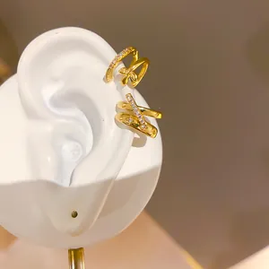 Vista detallada del elegante manguito de oreja dorado de doble capa con estrella de circón