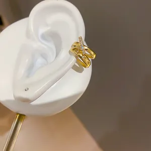 Vista detallada de un elegante pendiente de clip dorado con circonitas y estrellas