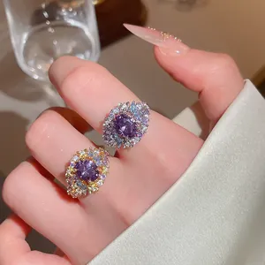 Detalle macro de dos lujosos anillos ovalados de circón púrpura bañados en oro y plata.