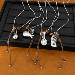 Stylish leather cord necklace set with silver comb, spoon, and fish pendants.