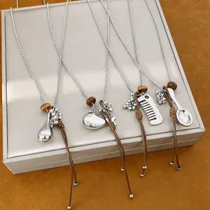Set of silver necklaces with unique comb, spoon, and fish pendants on brown leather cords
