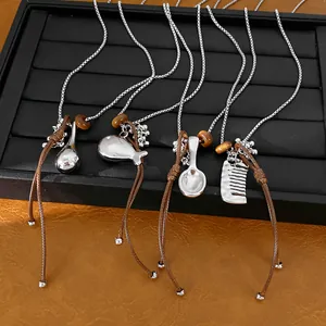 Detail of necklaces featuring unique comb, spoon, and fish pendants with leather cord