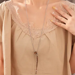 Close-up detail of a fashion necklace with resin comb, spoon and fish charms on leather cord