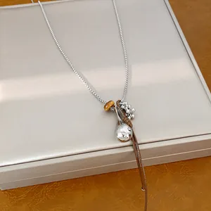 Detailed macro view of fashion sweater chain with silver spoon charm and leather cord
