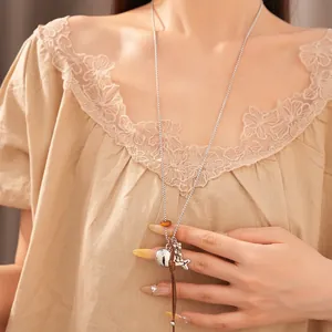 Detail shot of a stylish fish pendant necklace featuring resin beads and brown leather cord