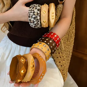 Vintage style geometric wooden bangles with gold and silver metallic studs shown on model arm