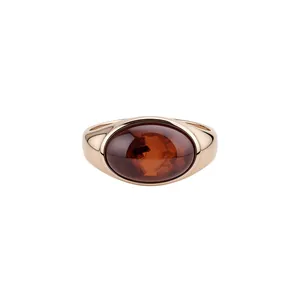 Elegant gold band ring with a large oval translucent brown stone and minimalist design