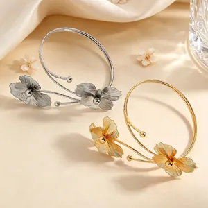 Elegant gold and silver hollow metal flower arm cuffs with detailed floral petals