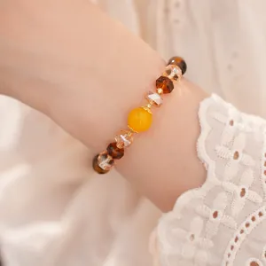 Primer plano de una pulsera vintage con cuentas de vidrio ojo de tigre en la muñeca