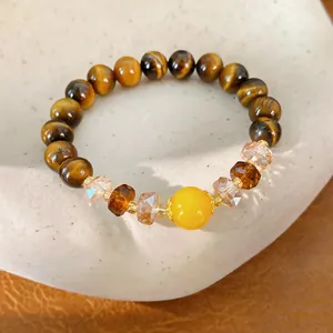 Vista detallada de cuentas de piedra de ojo de tigre y cristales de vidrio en una pulsera