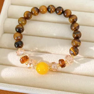 Primer plano de una pulsera de cuentas de ojo de tigre con una cuenta central amarilla