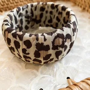 Macro view of leopard print fabric texture on a wide bohemian style bangle