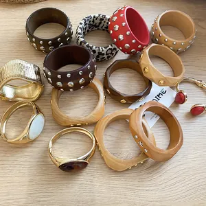 Detailed shot of assorted bohemian wooden bangles and metallic studded rivet bracelets