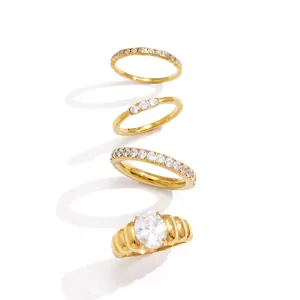 Juego de cuatro anillos de acero inoxidable dorados con piedras de circonita cúbica.