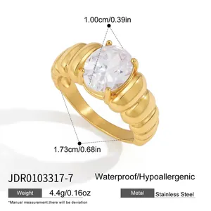 Anillo de lujo en acero inoxidable dorado con circonita ovalada y diseño de banda estriada
