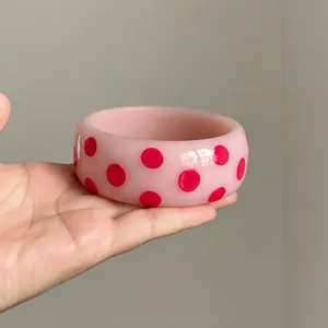 Trendy pink resin bangle bracelet with vibrant hot pink polka dots in dopamine style