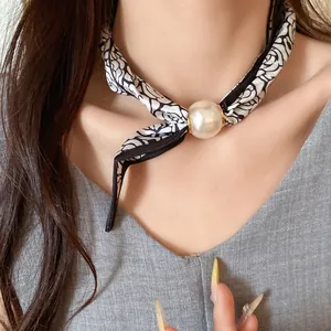 Vue détaillée d'un collier en foulard de soie avec pendentif perle de style français