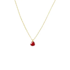 Collar minimalista de acero inoxidable dorado con un pequeño colgante de corazón rojo.
