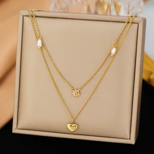 Vista detallada del collar de capas dorado con colgantes en forma de corazón y de estrella