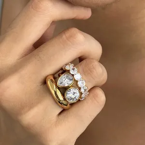 Detail van gestapelde goudkleurige roestvrijstalen ringen met zirkonia steentjes