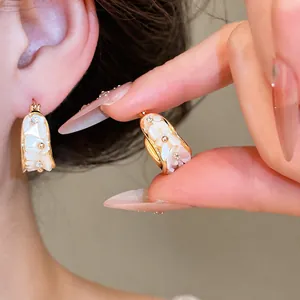 Elegantes pendientes de aro bañados en oro de 18k con flores de nácar